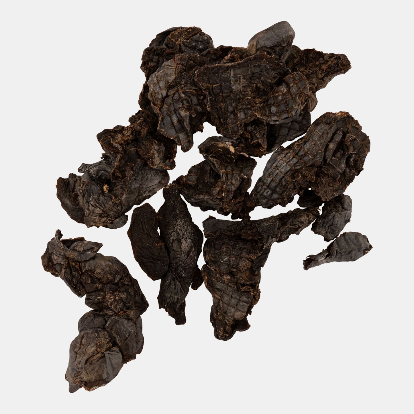 Dark brown dried tea leaves on a white background