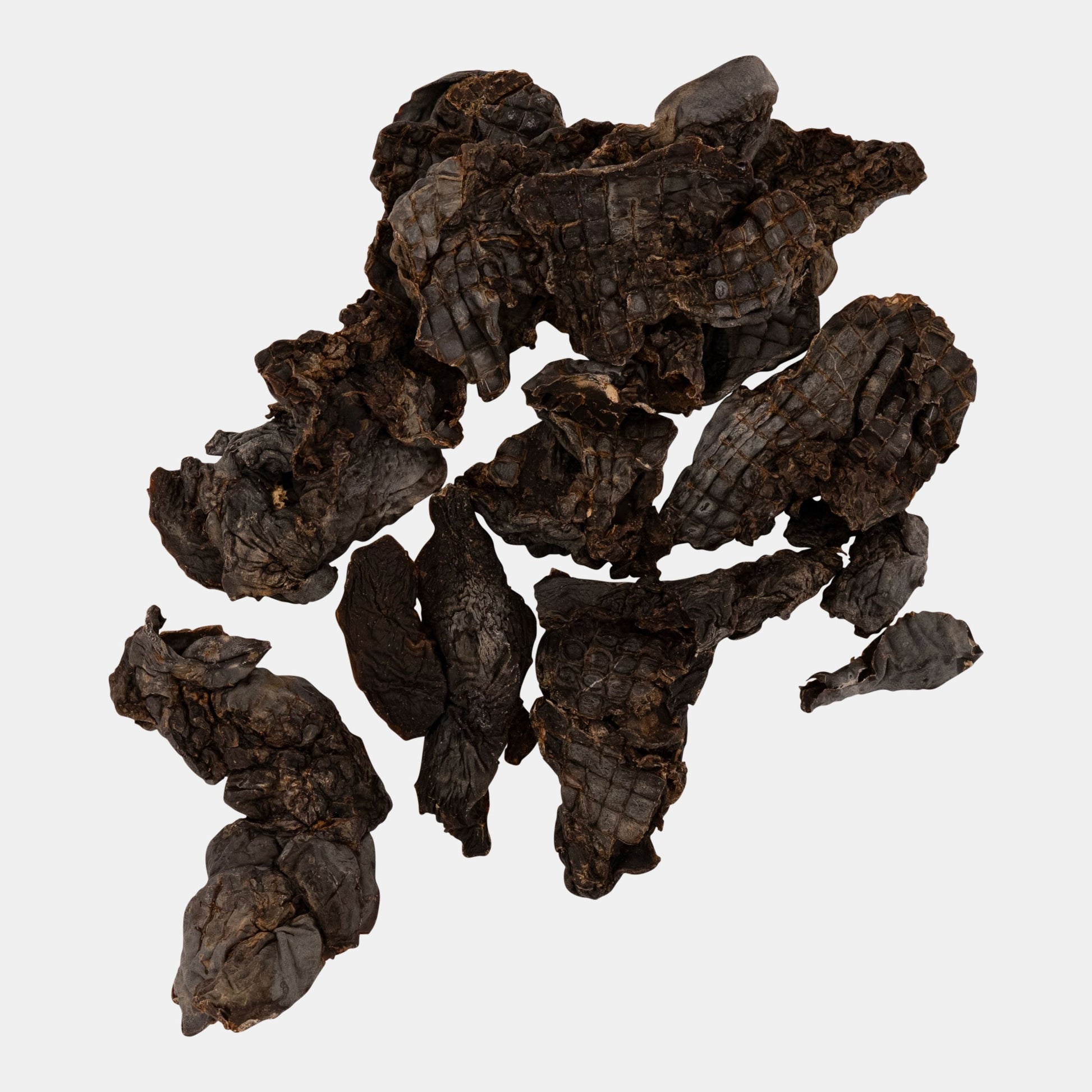 Dark brown dried tea leaves on a white background